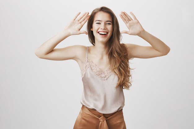 Foto gratuita mujer elegante alegre riendo y sonriendo con las manos arriba