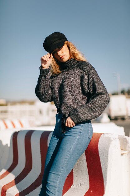 Mujer elegante apoyada contra barrera