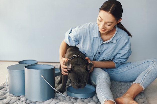 Mujer elegante en una camisa azul con bulldog negro