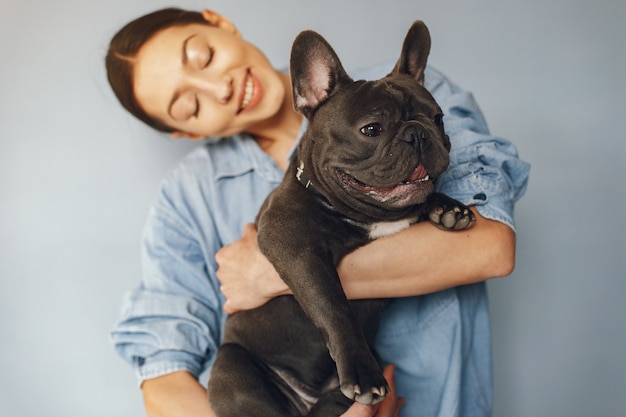 Mujer elegante en una camisa azul con bulldog negro