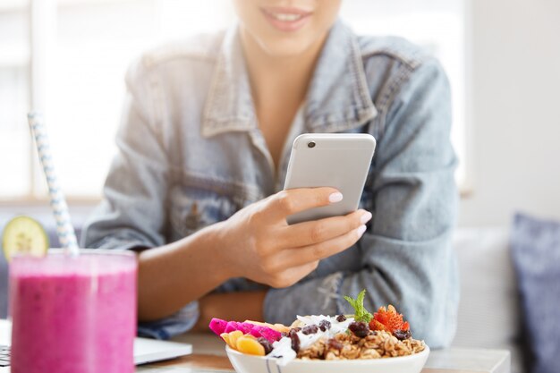 Mujer con elegante chaqueta vaquera en cafetería