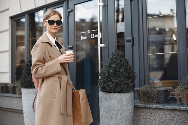 Mujer elegante en una ciudad de primavera con bolsas de compras