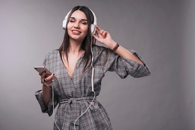 Mujer elegante disfrutando de la música con los ojos cerrados