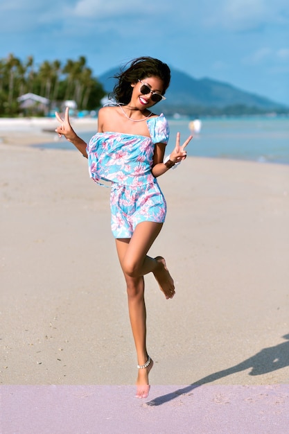 Mujer elegante divirtiéndose en la hermosa playa tropical