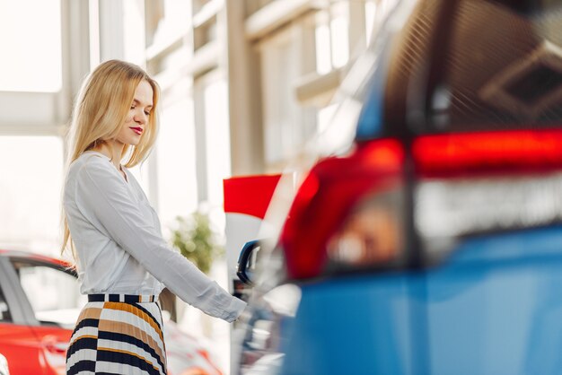 Mujer elegante y elegante en un salón de autos.