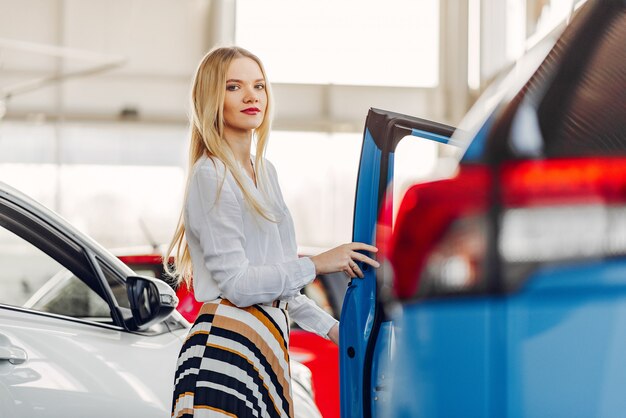 Mujer elegante y elegante en un salón de autos.