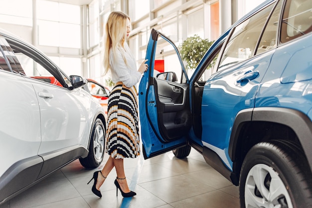 Mujer elegante y elegante en un salón de autos.