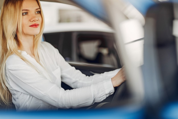 Foto gratuita mujer elegante y elegante en un salón de autos.