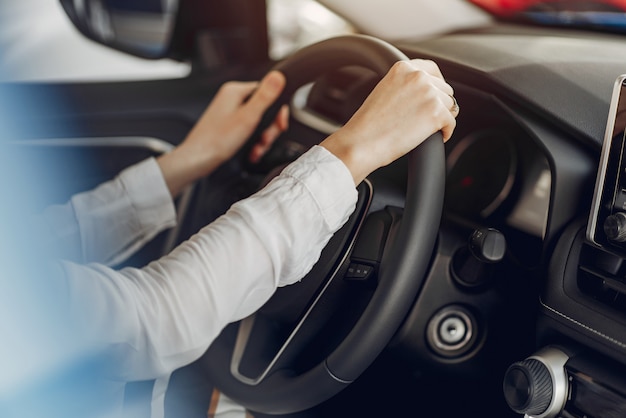 Mujer elegante y elegante en un salón de autos.