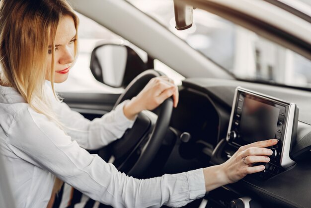 Mujer elegante y elegante en un salón de autos.