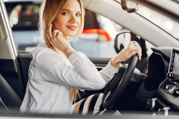 Mujer elegante y elegante en un salón de autos.