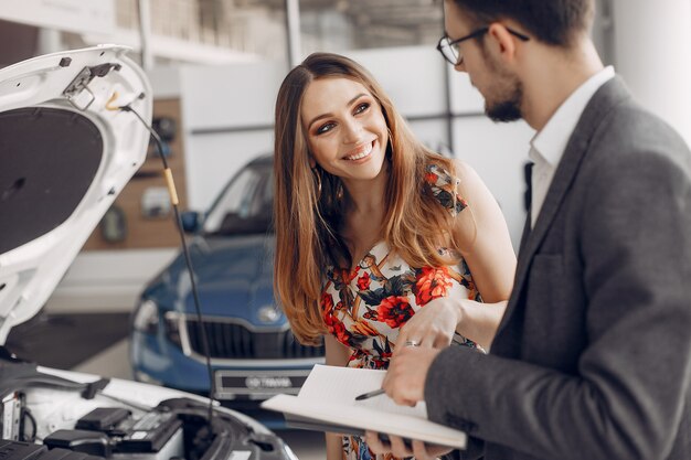 Mujer elegante y elegante en un salón de autos.