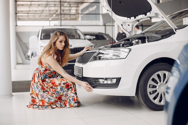 Mujer elegante y elegante en un salón de autos.