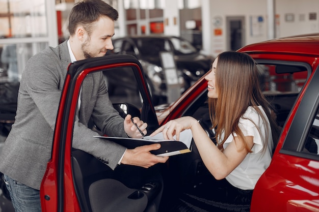 Mujer elegante y elegante en un salón de autos.