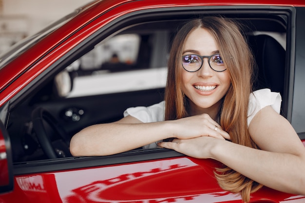 Mujer elegante y elegante en un salón de autos.