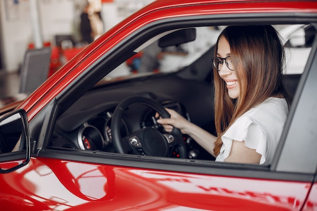 Mujer elegante y elegante en un salón de autos.