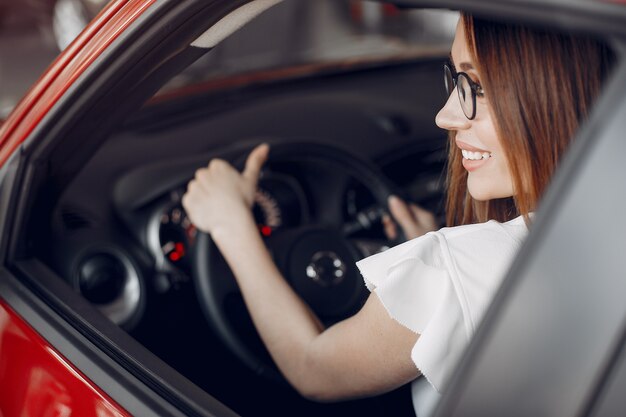 Mujer elegante y elegante en un salón de autos.