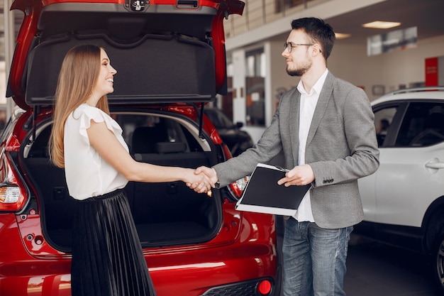 Mujer elegante y elegante en un salón de autos.