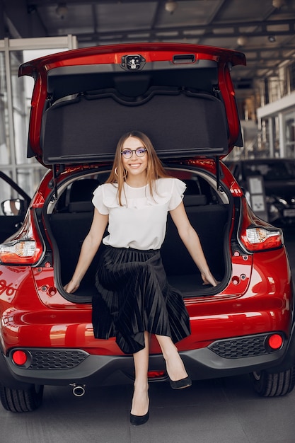 Mujer elegante y elegante en un salón de autos.