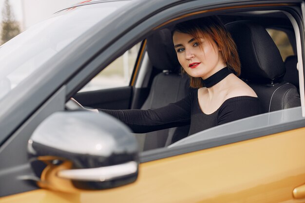 Mujer elegante y elegante en un salón de autos.