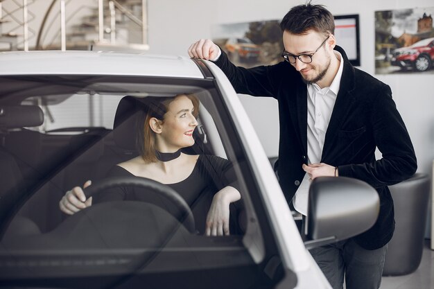 Mujer elegante y elegante en un salón de autos.