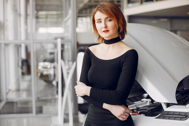 Mujer elegante y elegante en un salón de autos.