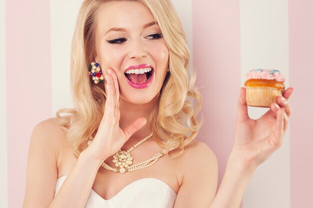 Mujer elegante emocionada con muffin