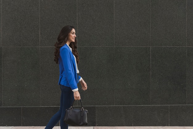 Mujer elegante feliz caminando 