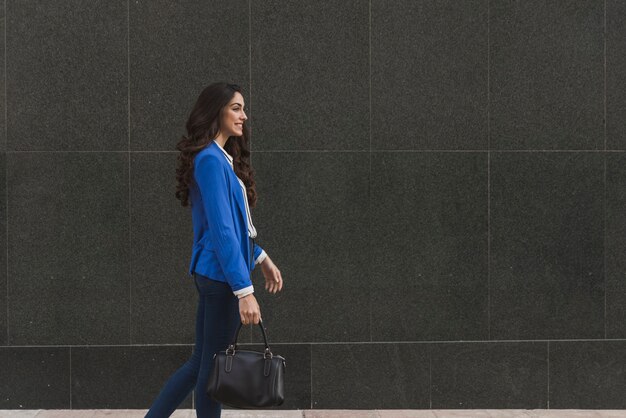 Mujer elegante feliz caminando 