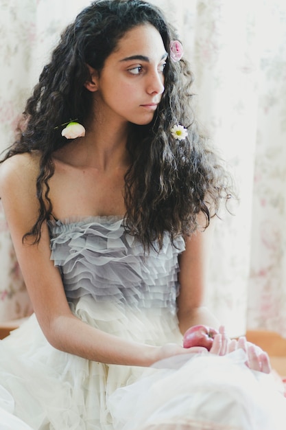 Mujer elegante con flores y manzana