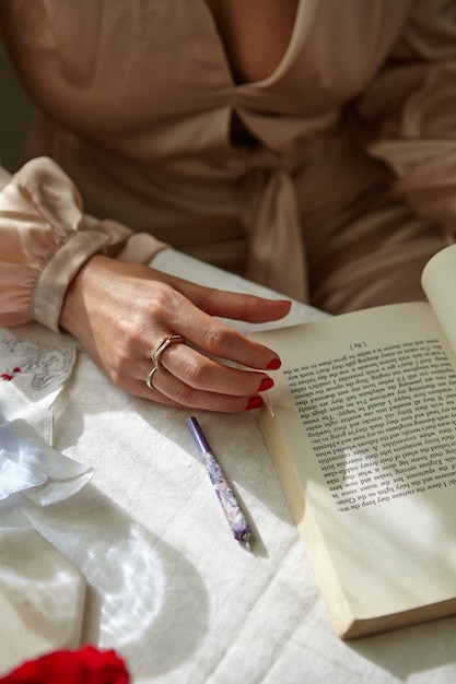 Foto gratuita mujer elegante fumando un porro en casa con un libro