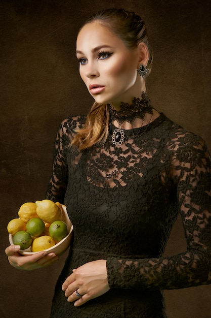 Mujer elegante con limones y limas