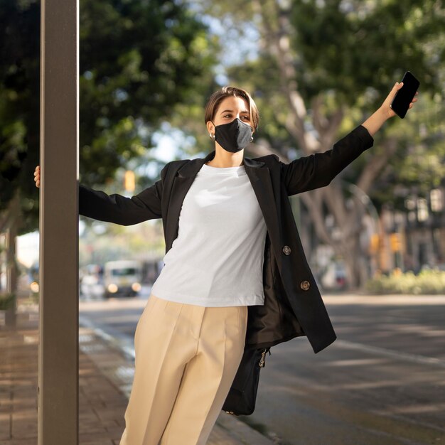 Mujer elegante con una máscara médica fuera