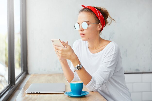 Mujer elegante con pañuelo sentado en el café