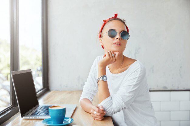 Mujer elegante con pañuelo sentado en el café