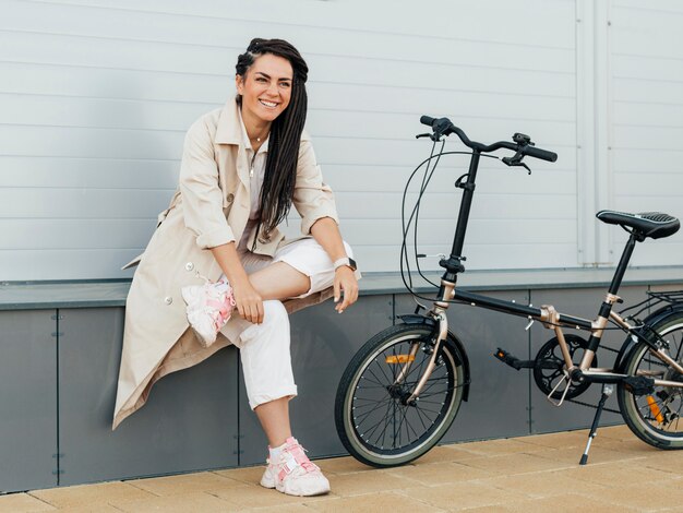 Mujer elegante posando con bicicleta