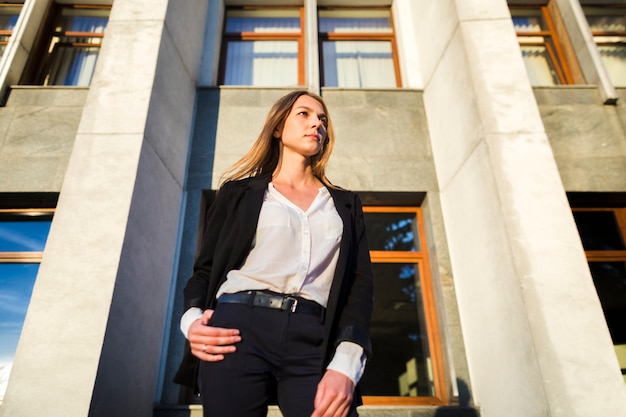 Mujer elegante que mira lejos el tiro de ángulo bajo