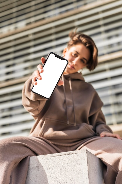 Foto gratuita mujer elegante sosteniendo un teléfono en blanco