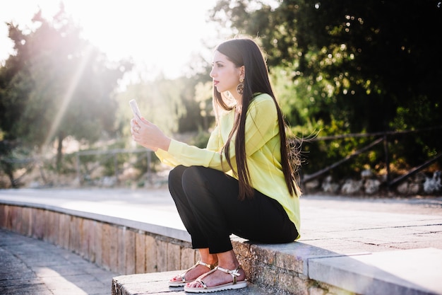 Mujer elegante con teléfono en el parque