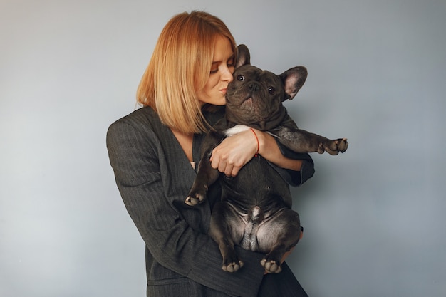 Mujer elegante en un traje negro con bulldog negro