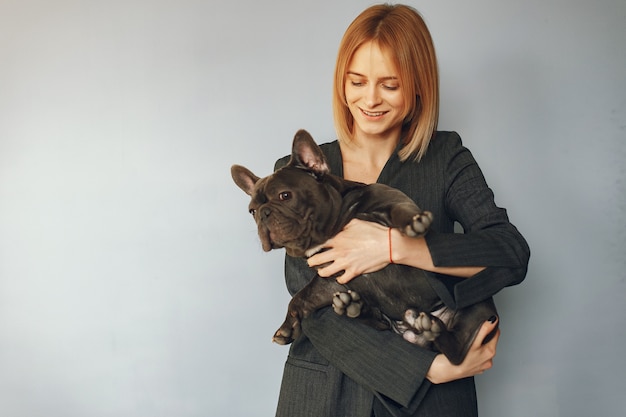 Mujer elegante en un traje negro con bulldog negro