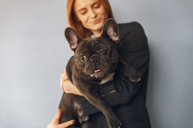 Mujer elegante en un traje negro con bulldog negro