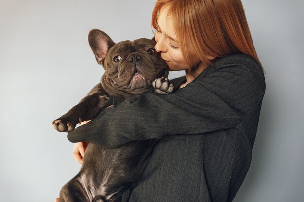 Mujer elegante en un traje negro con bulldog negro