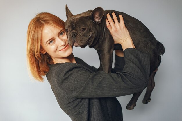 Mujer elegante en un traje negro con bulldog negro