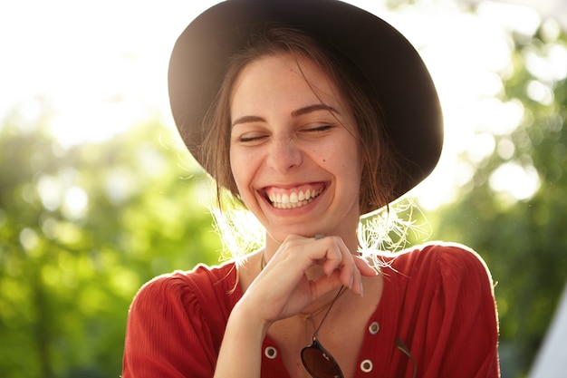 Foto gratuita mujer elegante vestida con blusa roja y sombrero grande