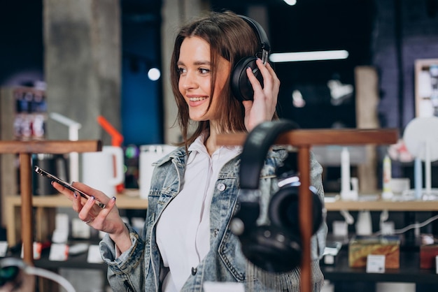 Mujer eligiendo auriculares en la tienda