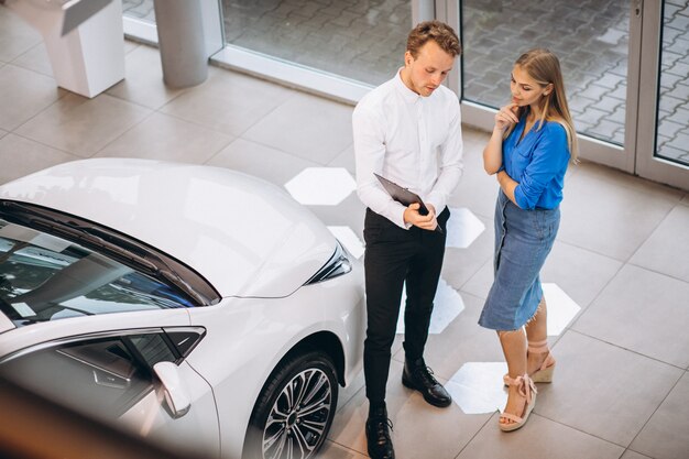 Mujer eligiendo un automóvil en una sala de exposición de automóviles