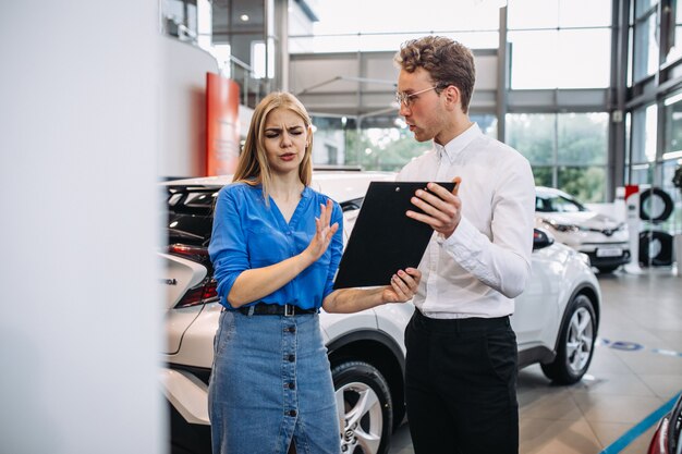 Mujer eligiendo un automóvil en una sala de exposición de automóviles