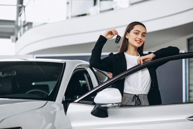 Mujer eligiendo un automóvil en una sala de exposición de automóviles