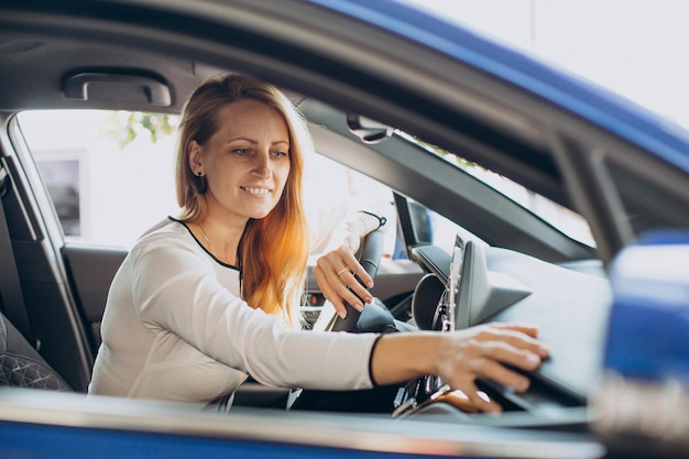 Mujer eligiendo un coche en una sala de exposición de coches